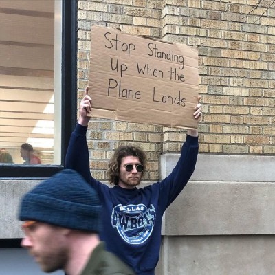 dude-with-sign-plane-landing.jpg